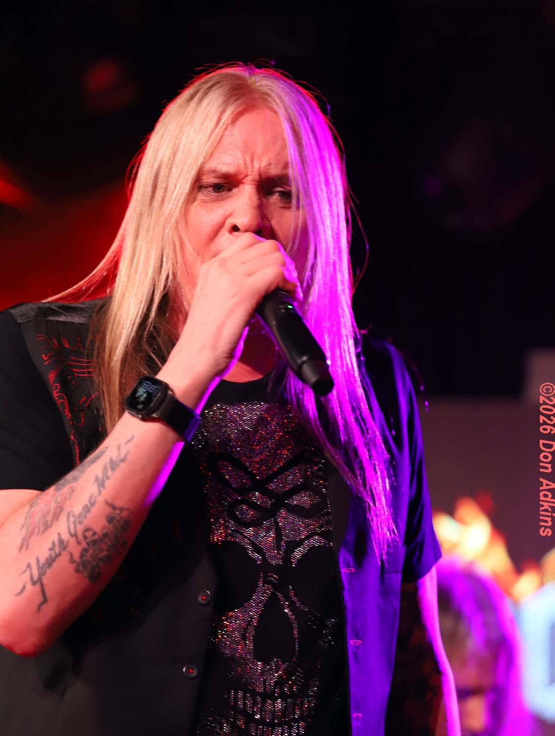 Sebastian Bach performing with mic under purple stage lights