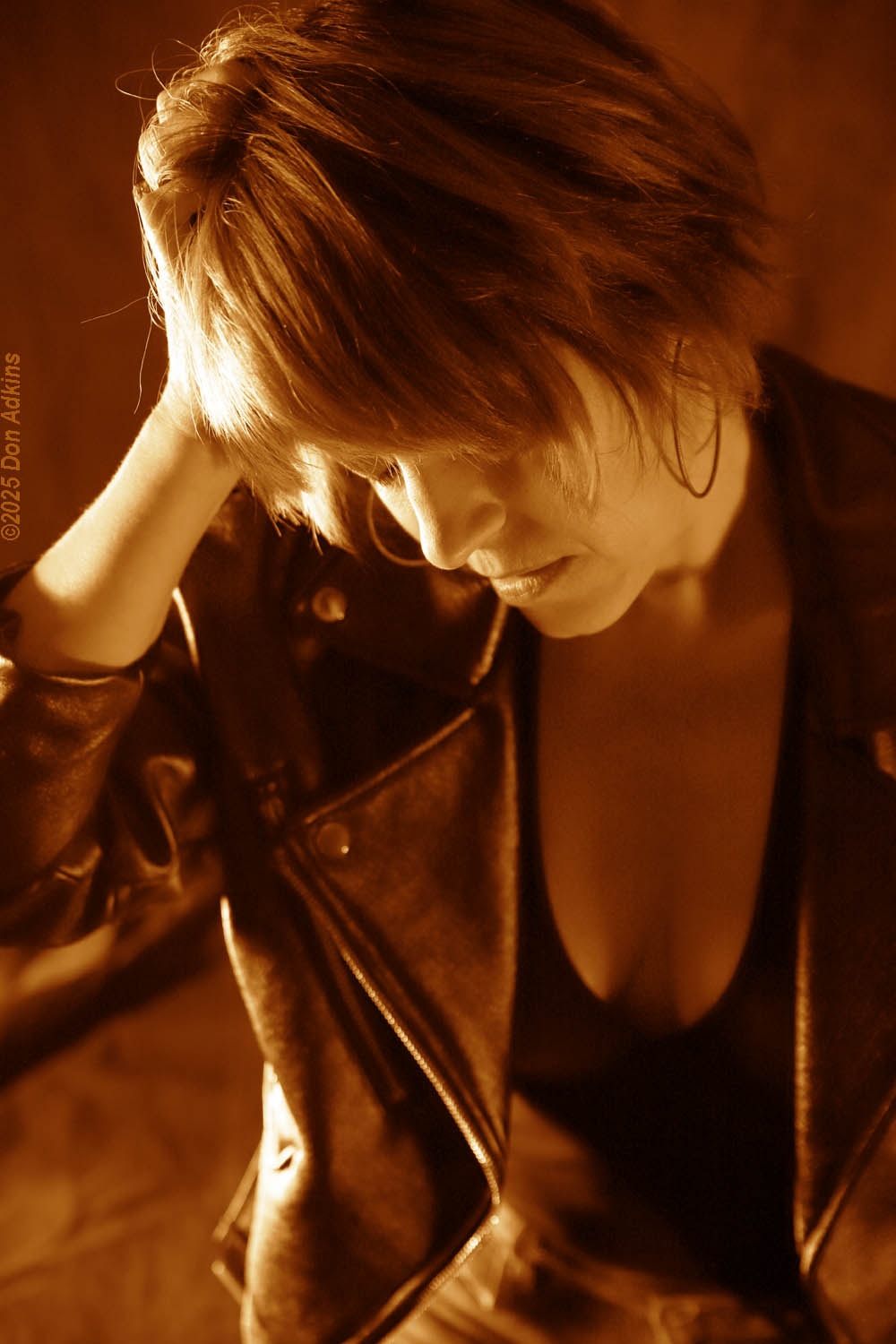 Emily Zuzik studio portrait in leather jacket with warm sepia tones